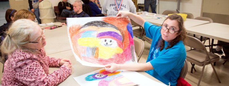 Photo of a person showing off their colorful drawing.
